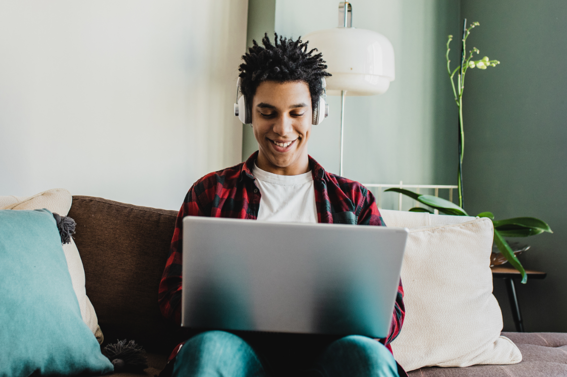 Student Sitting on Couch with laptop and headphone