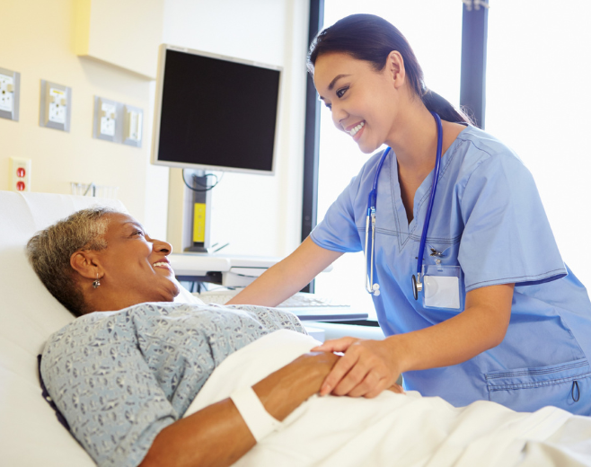healthcare professional communicates with patient in hospital bed