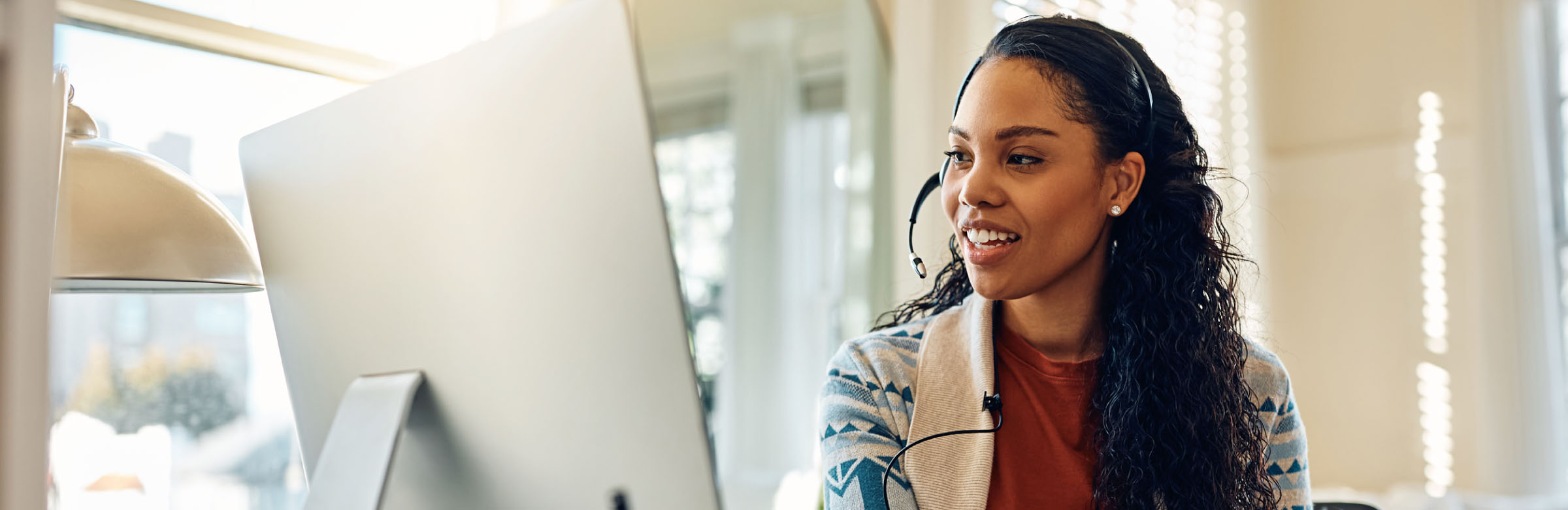 An IT person wearing a headset working at a computer