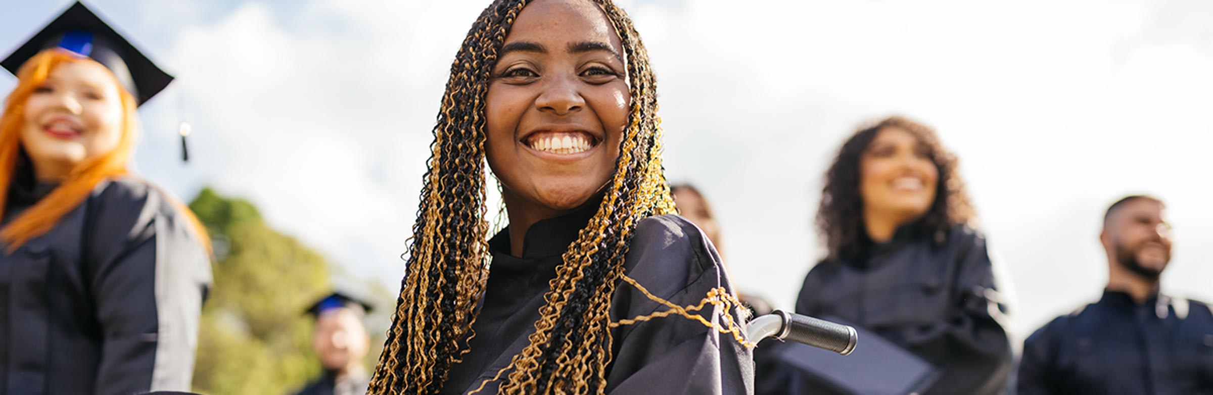 Several smiling graduates wearing caps and gowns on graduation day at one of the best colleges in Alberta.